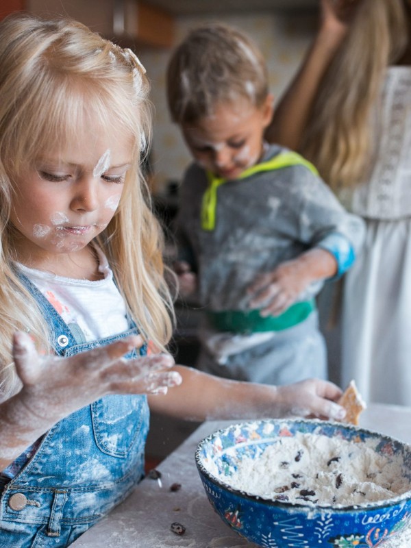 Little girl and boy helping mom to prepare the meal