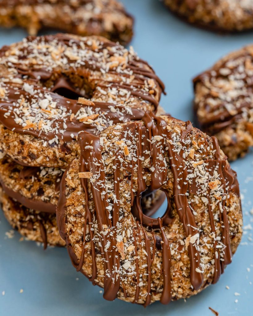 A stack of samoa cookies with one facing front and leaning on the stack.