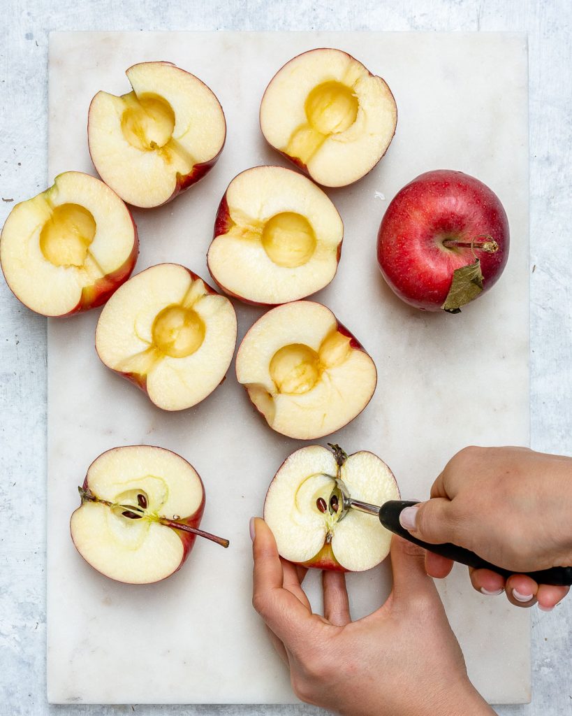 Apples cut in half arranged on a cutting board for apple recipes.