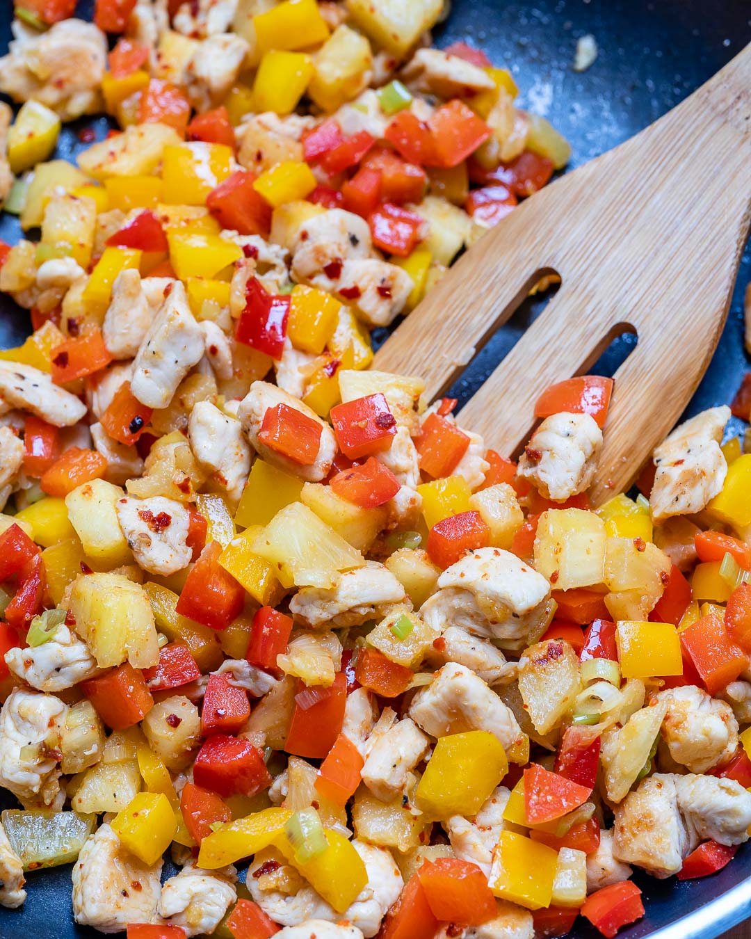 Veggies added to cooked chicken to make an easy healthy lunch of pineapple chicken bowls.