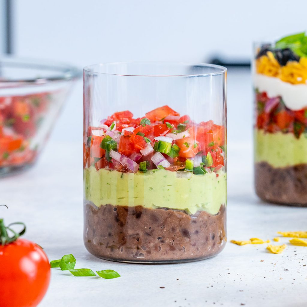 Bean, guacamole, and pico de gallo layers in seven layer dip.