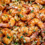 Close up image of Cajun shrimp and rice sprinkled with parsley.