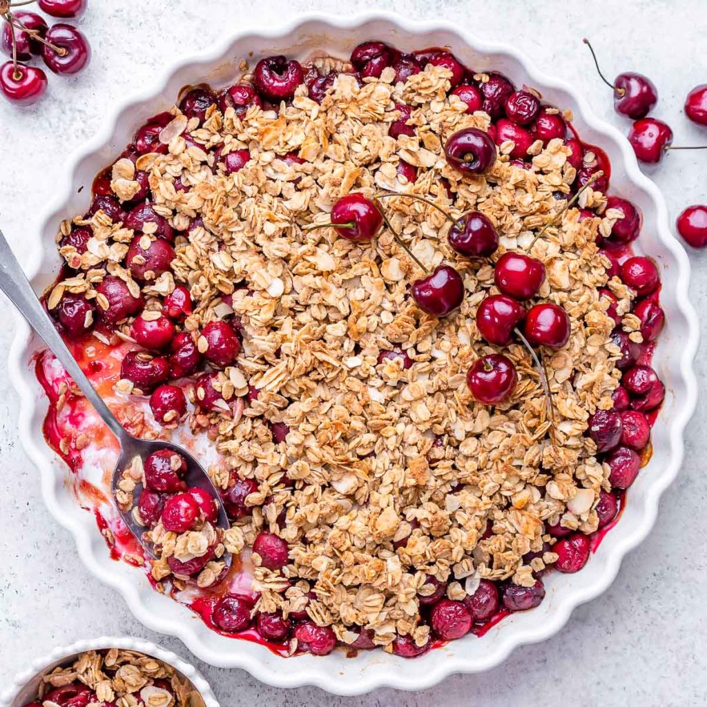 Cherry Crumble in a baking dish with a spoon.
