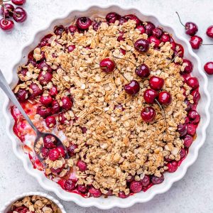 Cherry Crumble in a baking dish with a spoon.
