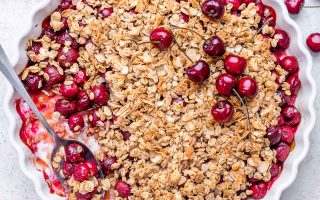 Cherry Crumble in a baking dish with a spoon.