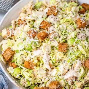 Brussels Sprout Caesar salad in a bowl with croutons.