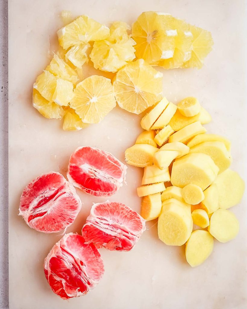 Grapefruit, oranges, and ginger root cut into segments.