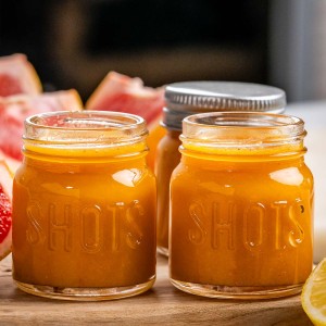 Two tiny glass jars that contain Homemade Immunity Shots.