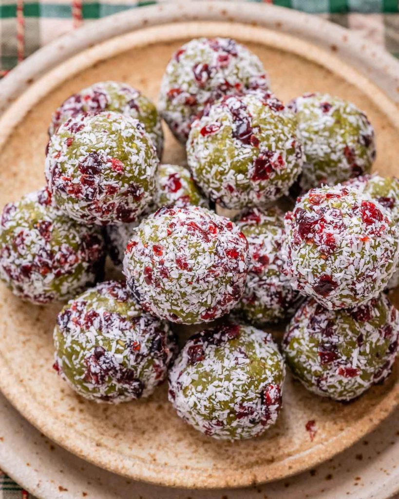 Christmas energy balls stacked up on a tan plate.