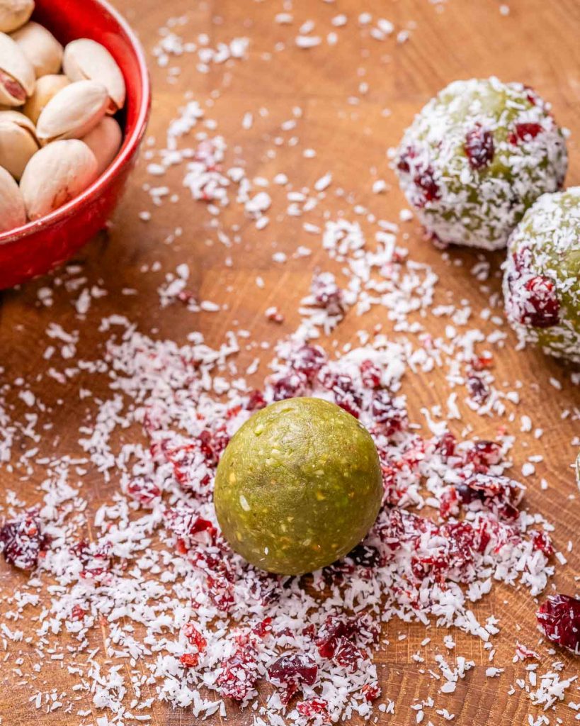 A green energy ball sitting on red and white sprinkles.