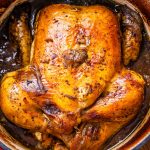 Image of a roasted balsamic chicken in a deep pan filled with brown liquid.