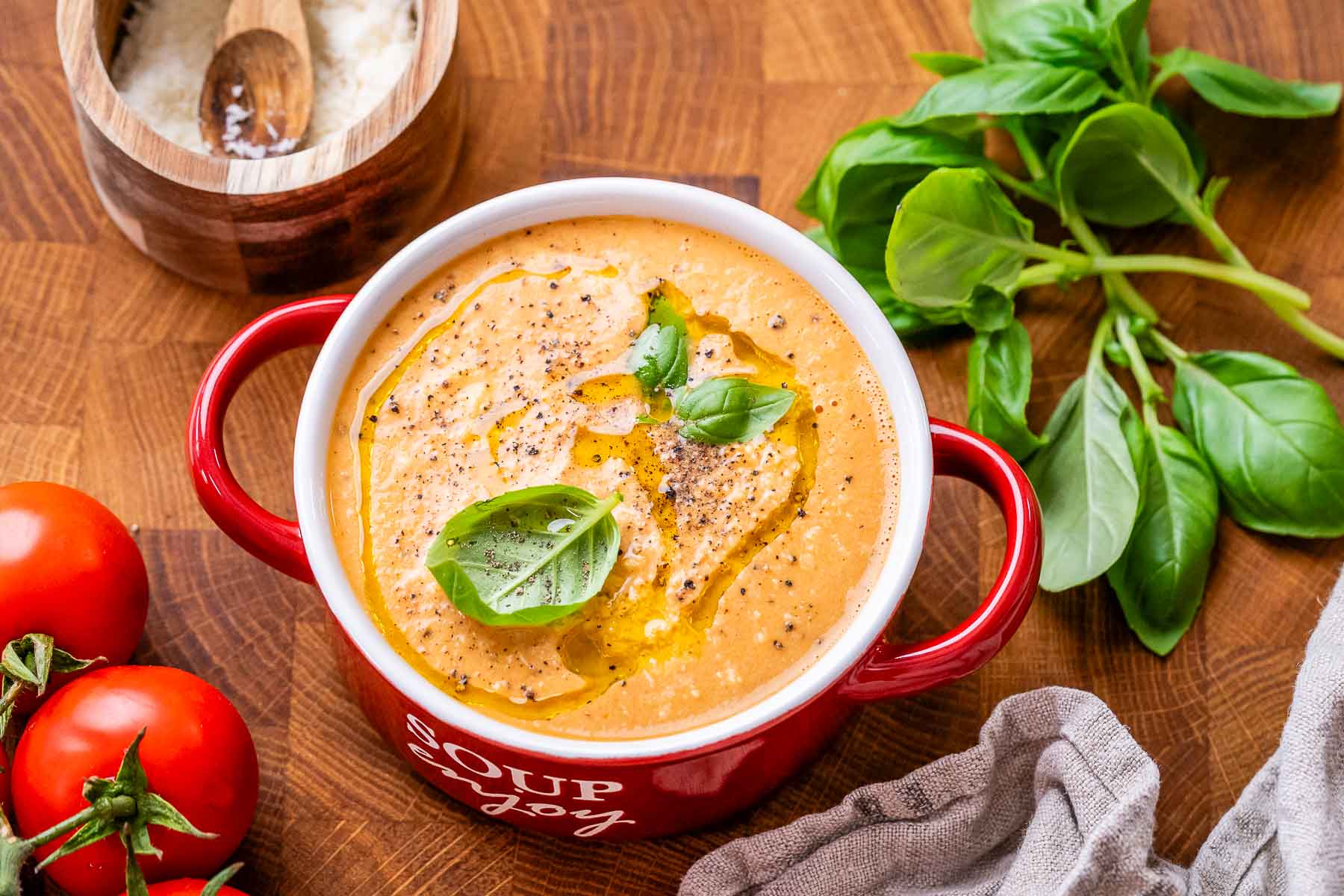 High Protein tomato soup with cottage cheese and chicken in a red bowl that says soup enjoy on the side.