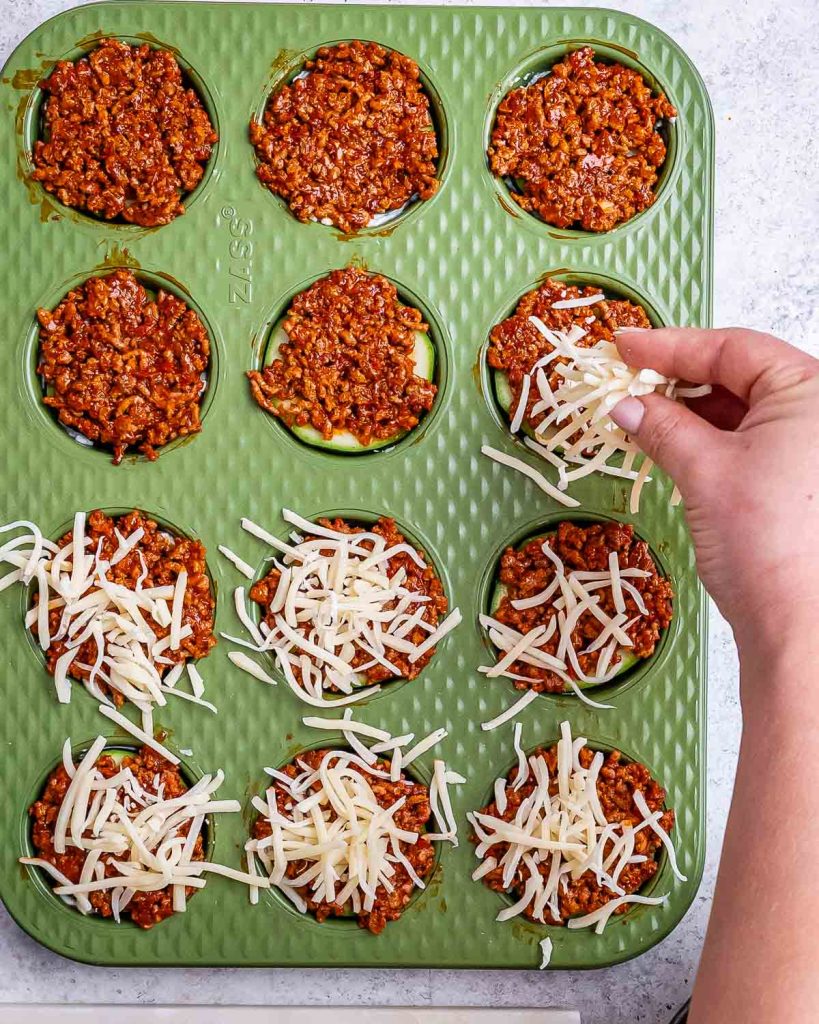 An additional layer of meaty sauce and cheese added to the zucchini lasagna bites in the muffin tin.