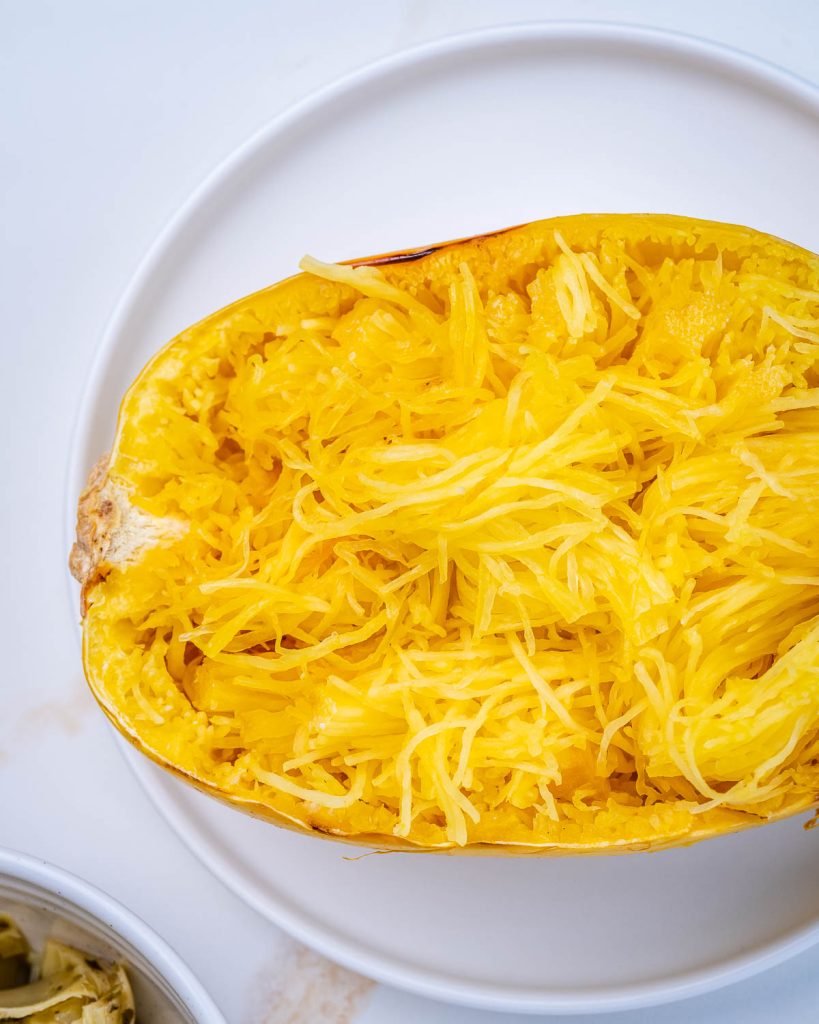 Spaghetti squash on a white plate on a white background.