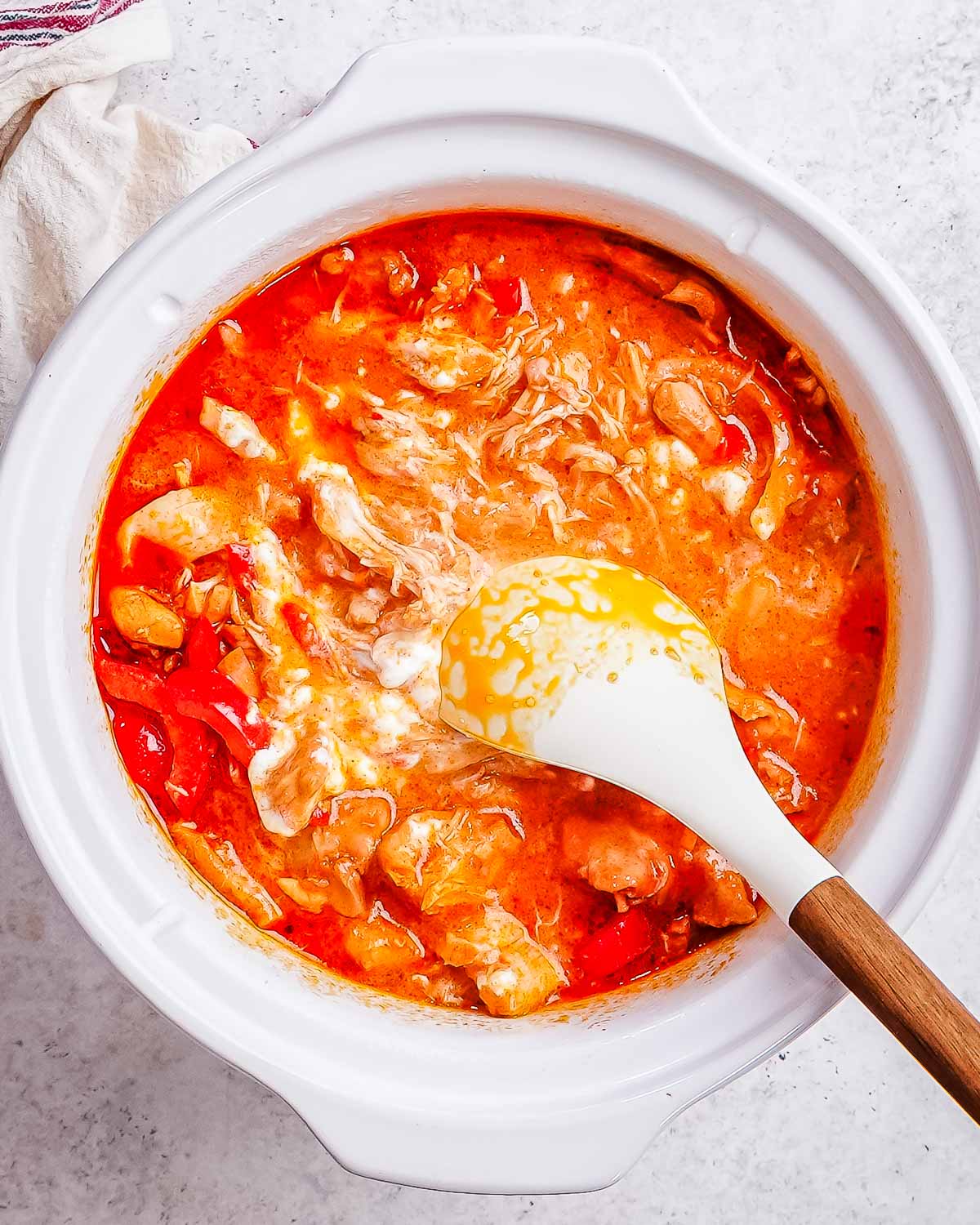 Yogurt being added to slow cooker chicken paprika.