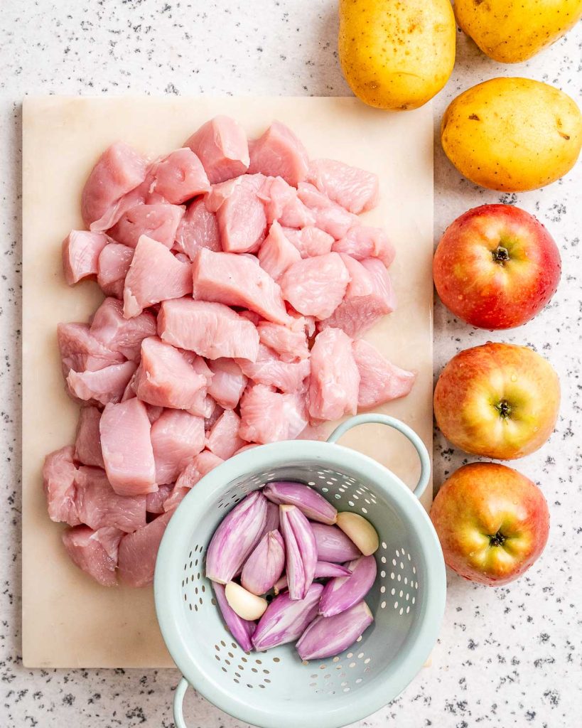 Ingredients to make turkey stew like apples, turkey breast, and shallots.