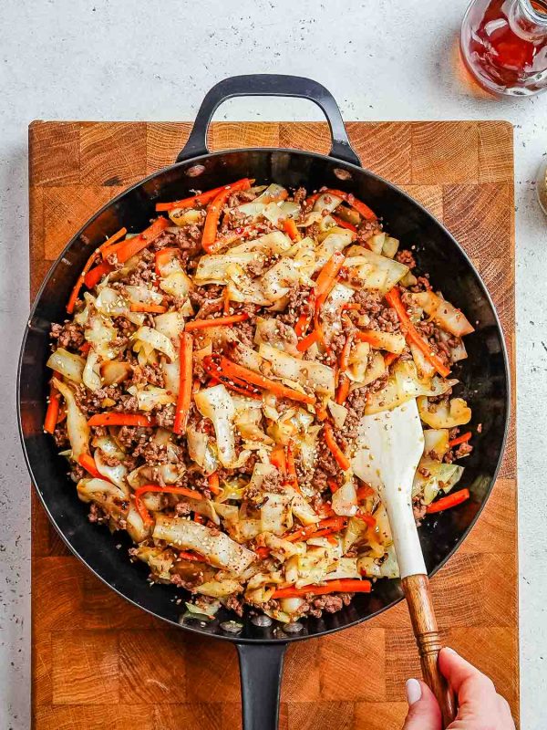 Ground beef and cabbage stir fry in a skillet.
