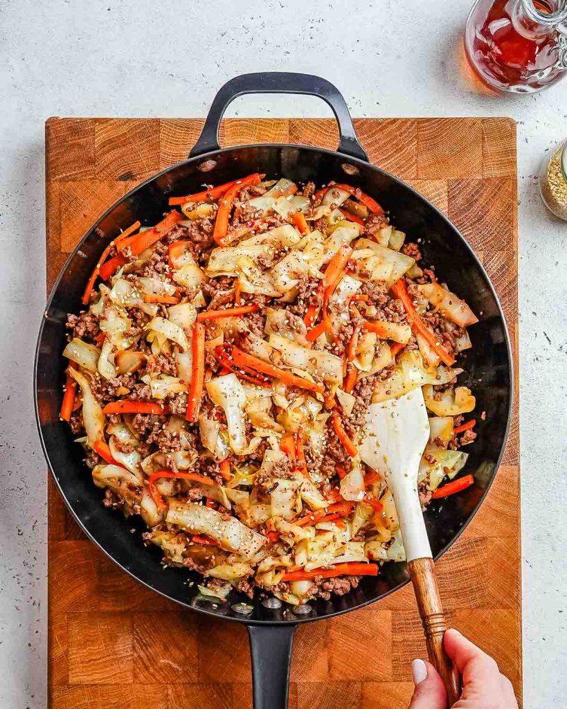 Ground beef and cabbage stir fry in a skillet.