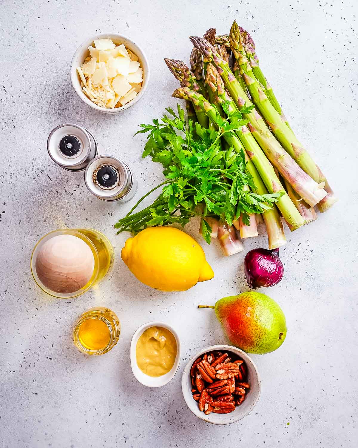 ingredients to make an asparagus salad with lemon vinaigrette laid out.