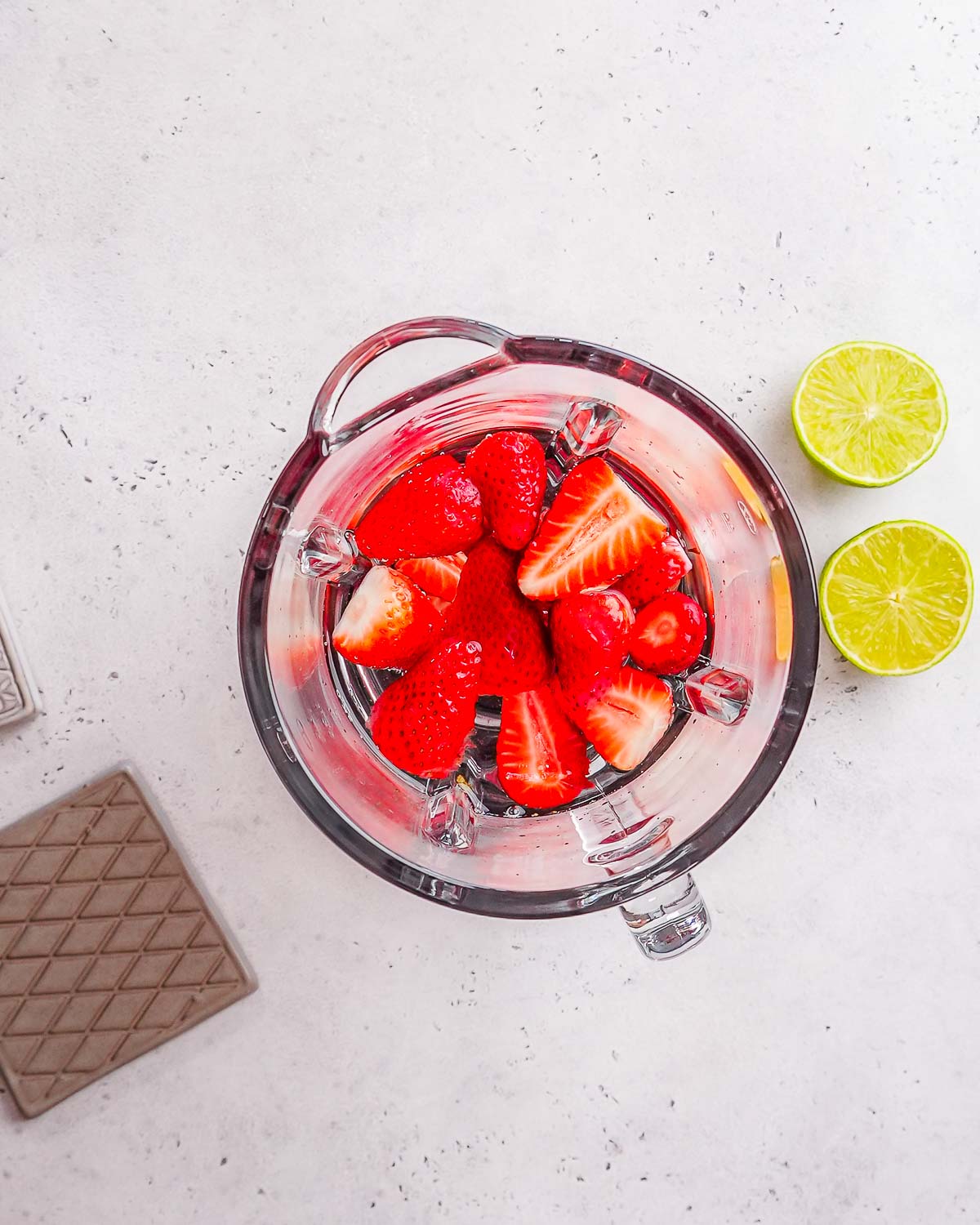 Strawberries in a blender to make strawberry electrolyte drink.