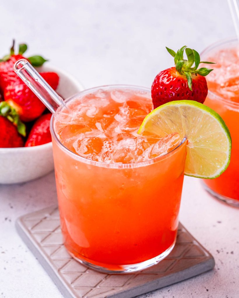 homemade electrolyte drink in a glass and garnished with a strawberry and lime.